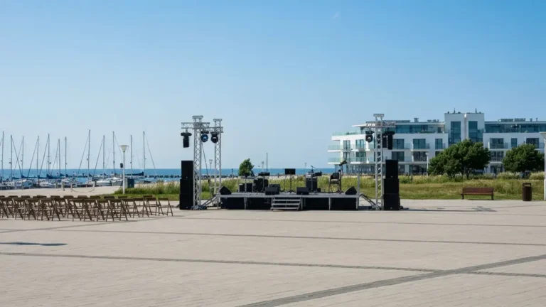 Plenerowa scena koncertowa przy nabrzezu w Gdyni z morzem i modernistyczna zabudowa w tle